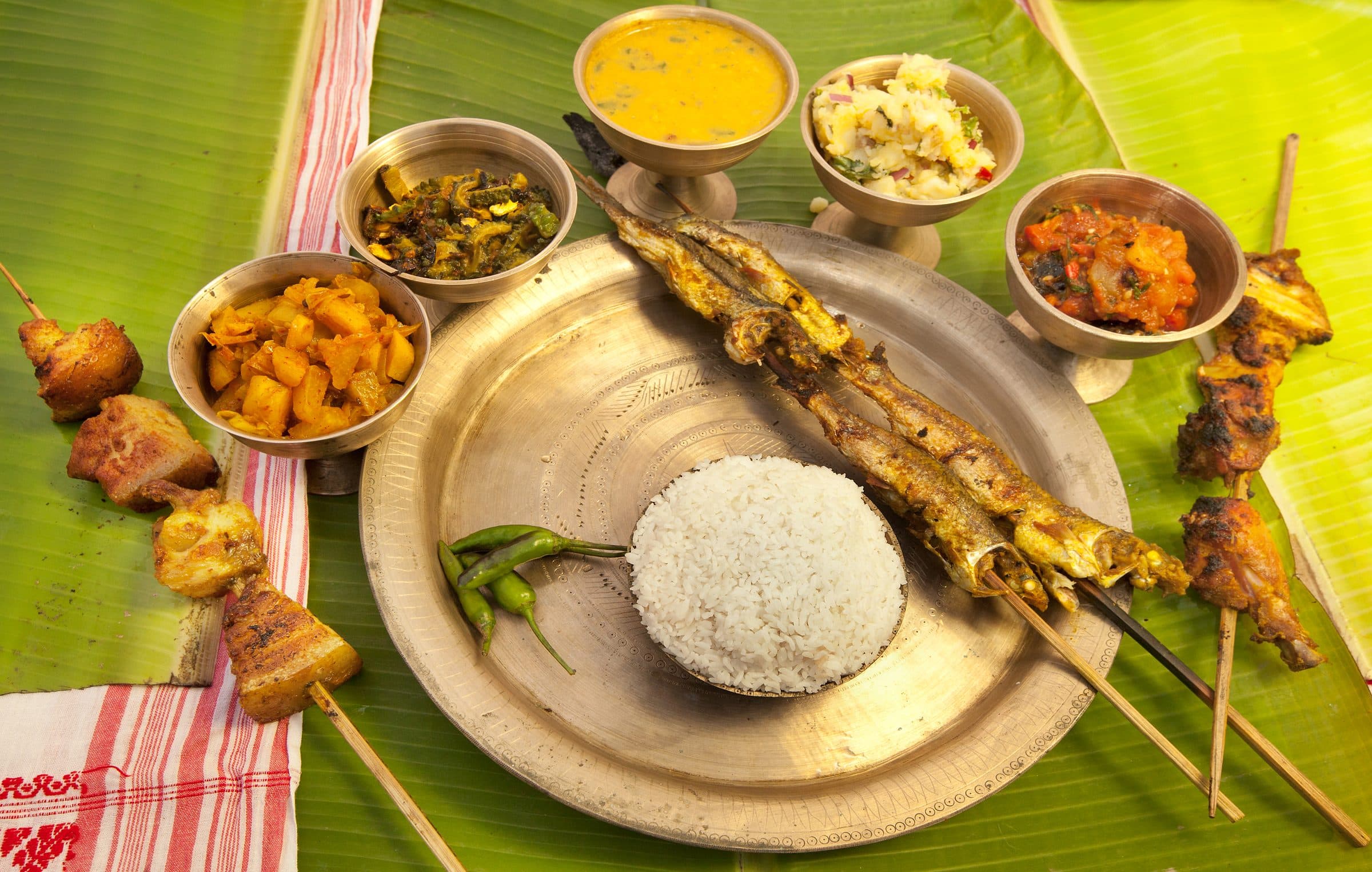 Traditional Assamese thali with rice, dal, fish, and vegetables